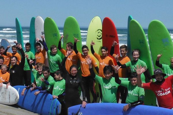 students poses after their surf lessons